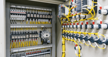Interior of an industrial electrical control panel with labelled wiring and modular switchgear components