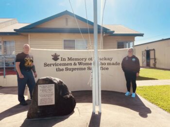 Two PowerControl Industries representatives standing beside the Mackay Veterans’ Memorial, marking a community donation to support local servicemen and women