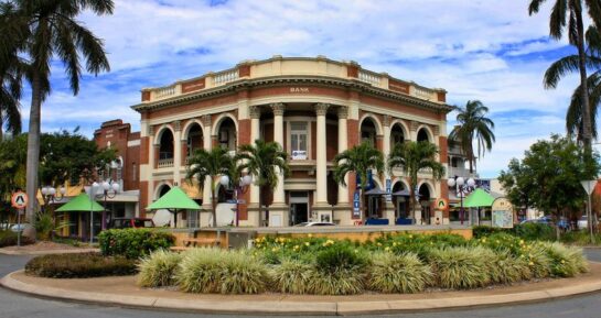 Historic building in Mackay’s City Heart surrounded by palm trees and landscaped gardens.